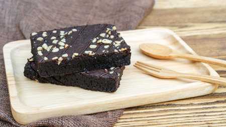 Brownies cake, spoon, and fork on a wooden table.の写真素材