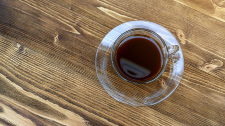 A cup of hot black coffee on a wooden table.の写真素材
