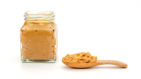 Peanut butter in a spoon and bottle on a white background.の写真素材