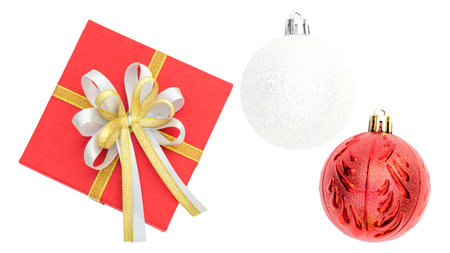 Red gift box, gold ribbon, and Christmas ball on a white background.の写真素材
