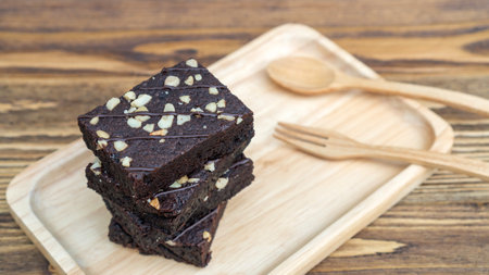 Brownies, spoon, and fork on a wooden table.の写真素材