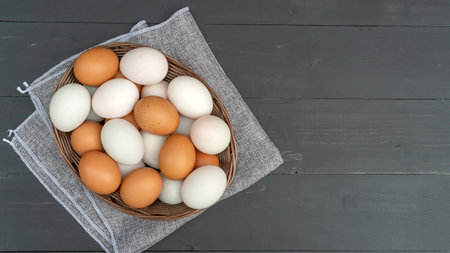 Chicken egg and duck egg on a black wooden table.の写真素材
