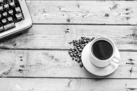 BW coffee cup coffee beans and typewriter on wooden backgroundの写真素材