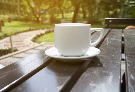 a cup of coffe on table in garden at sunny day, blurredの写真素材