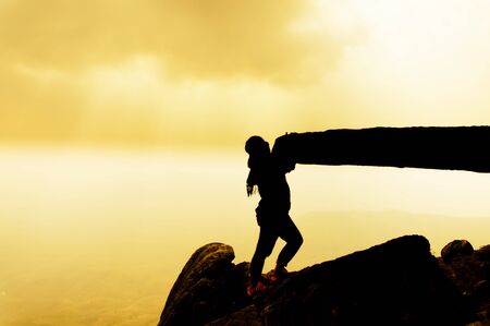 silhouette woman sit on rock top mountain, blurredの写真素材