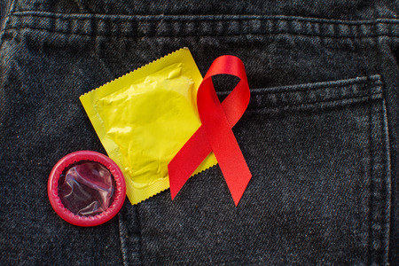 Red ribbon and condom World Aids day concept.の写真素材