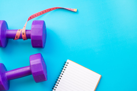Fitness equipment dumbbells on color background. Flat lay.