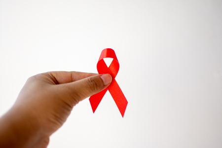 Red ribbon on hand with World Aids day concept.の写真素材