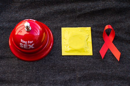 Red ribbon and condom World Aids day concept.の写真素材