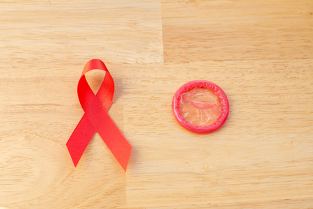 Red ribbon and condom World Aids day concept.