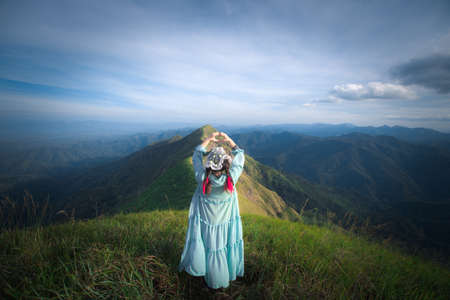 happy hiking woman on top of mountain at Khao Chang Puak, Thongphaphum National Park, Kanchanaburi Province, Thailand. Subject is blurred, noise and color effect.の写真素材