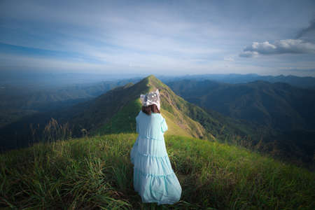 happy hiking woman on top of mountain at Khao Chang Puak, Thongphaphum National Park, Kanchanaburi Province, Thailand. Subject is blurred, noise and color effect.の写真素材