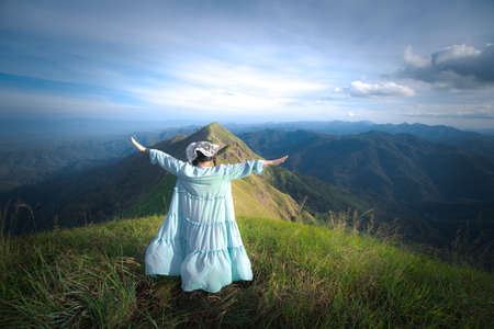 happy hiking woman on top of mountain at Khao Chang Puak, Thongphaphum National Park, Kanchanaburi Province, Thailand. Subject is blurred, noise and color effect.の写真素材