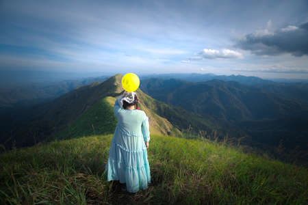 happy hiking woman on top of mountain at Khao Chang Puak, Thongphaphum National Park, Kanchanaburi Province, Thailand. Subject is blurred, noise and color effect.の写真素材