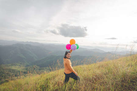 happy hiking woman on top of mountain at Khao Chang Puak, Thongphaphum National Park, Kanchanaburi Province, Thailand. Subject is blurred, noise and color effect.の写真素材
