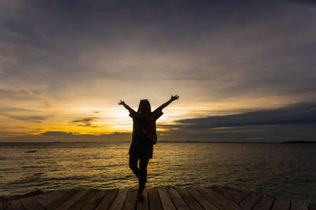 silhouette of woman jumping on the sea at sunset. soft focus and low key