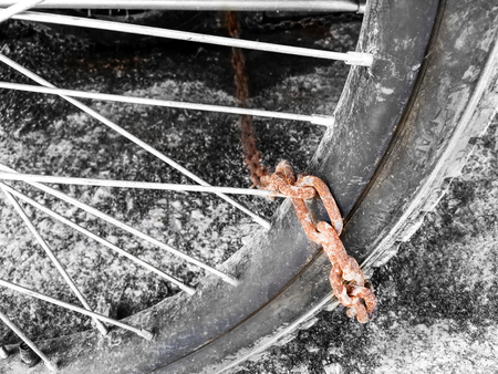 Rusty Chain Tied with Black and White Wheelの写真素材