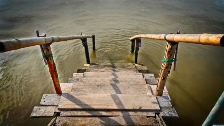 Small Wooden Plank Staircase with Bamboo Handrail to the Seaの写真素材