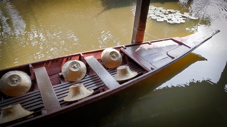 Floating Wooden Boat with Farmer's Hats Docked and Tied with Pillarの写真素材
