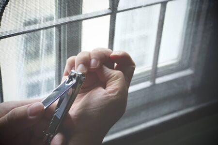 Close-up clipper and nail clipping on woman's handの写真素材