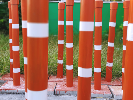 Orange Traffic Pillars in Rows Beside Grass Field