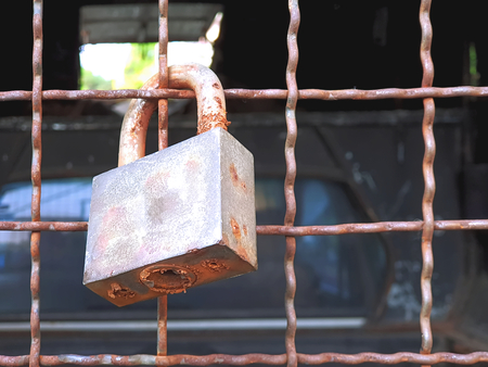 Old Rusty Lock Hanging On Steel Meshの写真素材