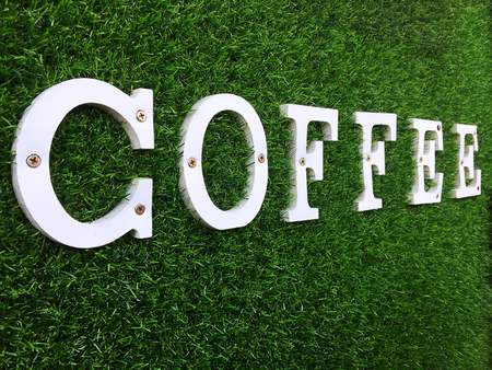 White Wooden COFFEE Text on Green Grass Wallの写真素材