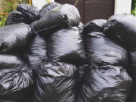 Pile of Black Plastic Garbage Bags on Streetの写真素材
