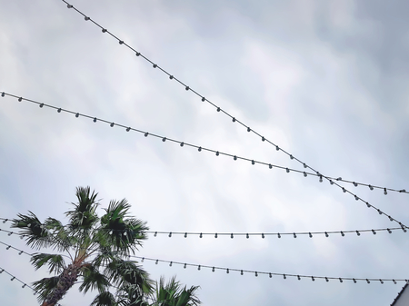 Low Angle View of Lightbulbs with Cables Against Cloudy Sky