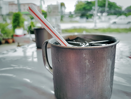 Close-up Cold Iced Water in Stainless Steel Cup with Strawの写真素材