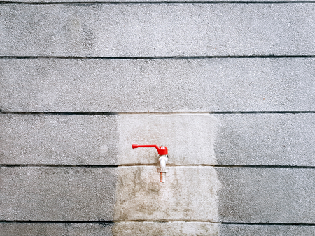 Red Water Faucet on Grungy Striped Wallの写真素材