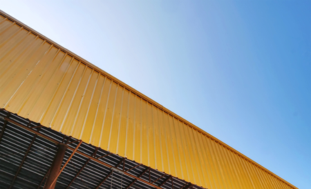 Low Angle View of Yellow Corrugated Roof Exterior Against Blue Sky