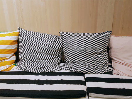 Cushioning Seats with Patterned Pillows Against Wooden Wall on the Backの写真素材