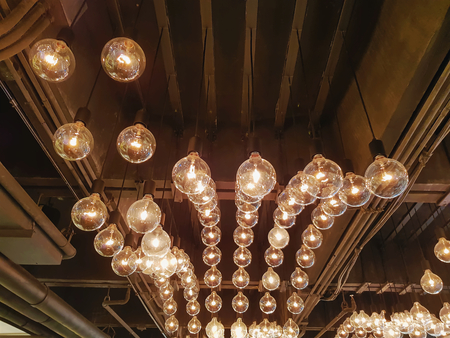 Retro Decorative Hanging Illuminated Light Bulbs Inside the Roomの写真素材