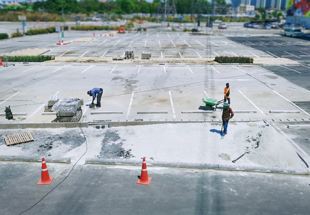 Unrecognizable Construction Workers Working at Parking Lotの写真素材