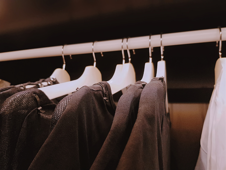 Close-up Casual Clothing Shirts Hanging Inside the Wardrobe with Selective Focusの写真素材
