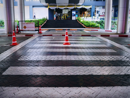 Orange Plastic Traffic Cones with White Stripes on Street at Zebra Crossingの写真素材