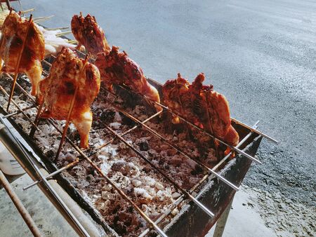 Thai-Style Street Food. Grilled Spicy Chickens on Small Stove.