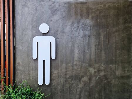 White Men's Toilet Symbol on Bare Concrete Wallの写真素材