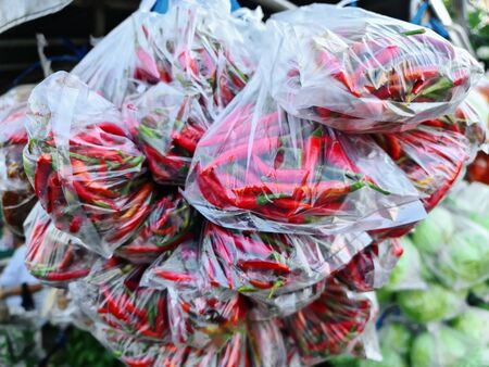 Close-up Fresh Red Hot Chilies in Plastic Bags for Saleの写真素材