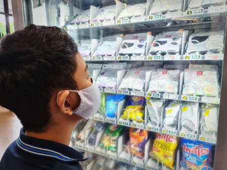 Bang Kaeo, Samut Prakarn / Thailand - May 30, 2020: Kid Wearing Mask Standing in Front of Mask Vending Machineのeditorial素材