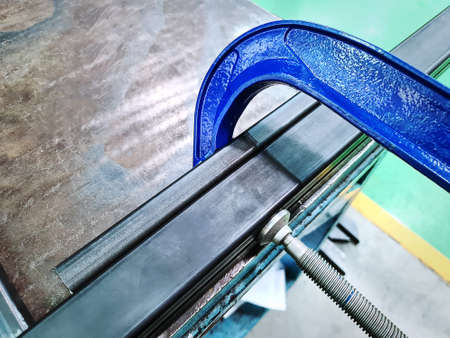 Blue C-Clamp Holding Metal Profile Frames Together at Workshopの写真素材