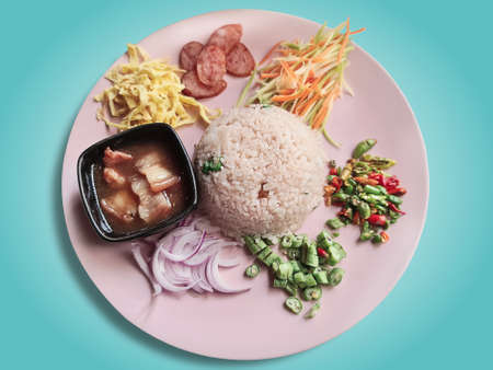 Thai Shrimp Paste Fried Rice with Sweet Pork and Other Seasoning Ingredients Isolated on Blue