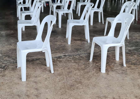Rows of Empty White Plastic Chairs
