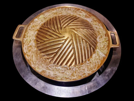 High Angle View of Hot Empty Brass Barbecue Pan with Sliced Cabbage Isolated on Black