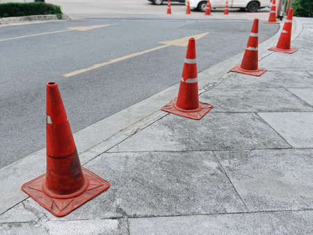 Row of Old Orange Plastic Traffic Cones Along the Roadの写真素材