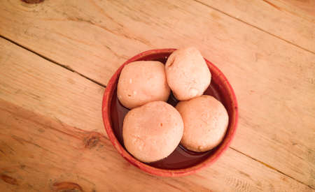 nolen gur rosogolla or rasgulla served on plate. brown spongy bengali indian traditional sweet made...