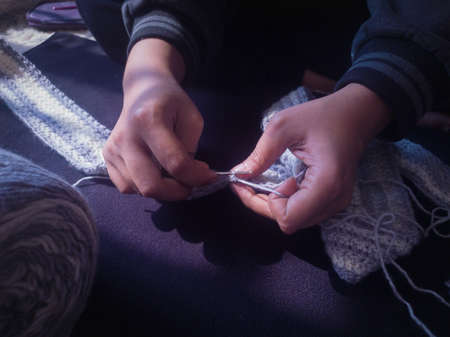 rural woman crochette knitting with crochet hook by hand. close up shot in natural light.の写真素材