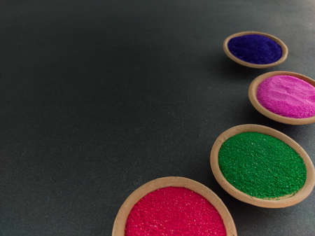 colorful powders for holi on clay pots on occasion of indian festival of colors. happy holi theme shot against black background. copy space for text.の写真素材
