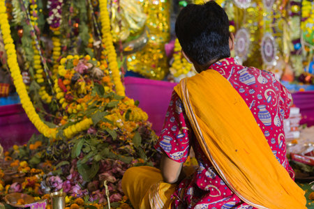 puja rituals being performed by hindu priest with flowers and other condiments during kali puja, durga puja and other festivals in india.の写真素材